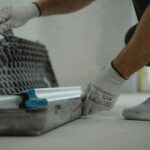 A construction worker organizing tools inside a toolbox on a job site.